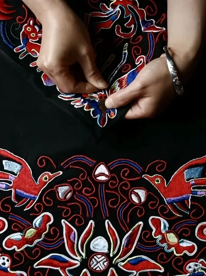Hands working verified embroidery