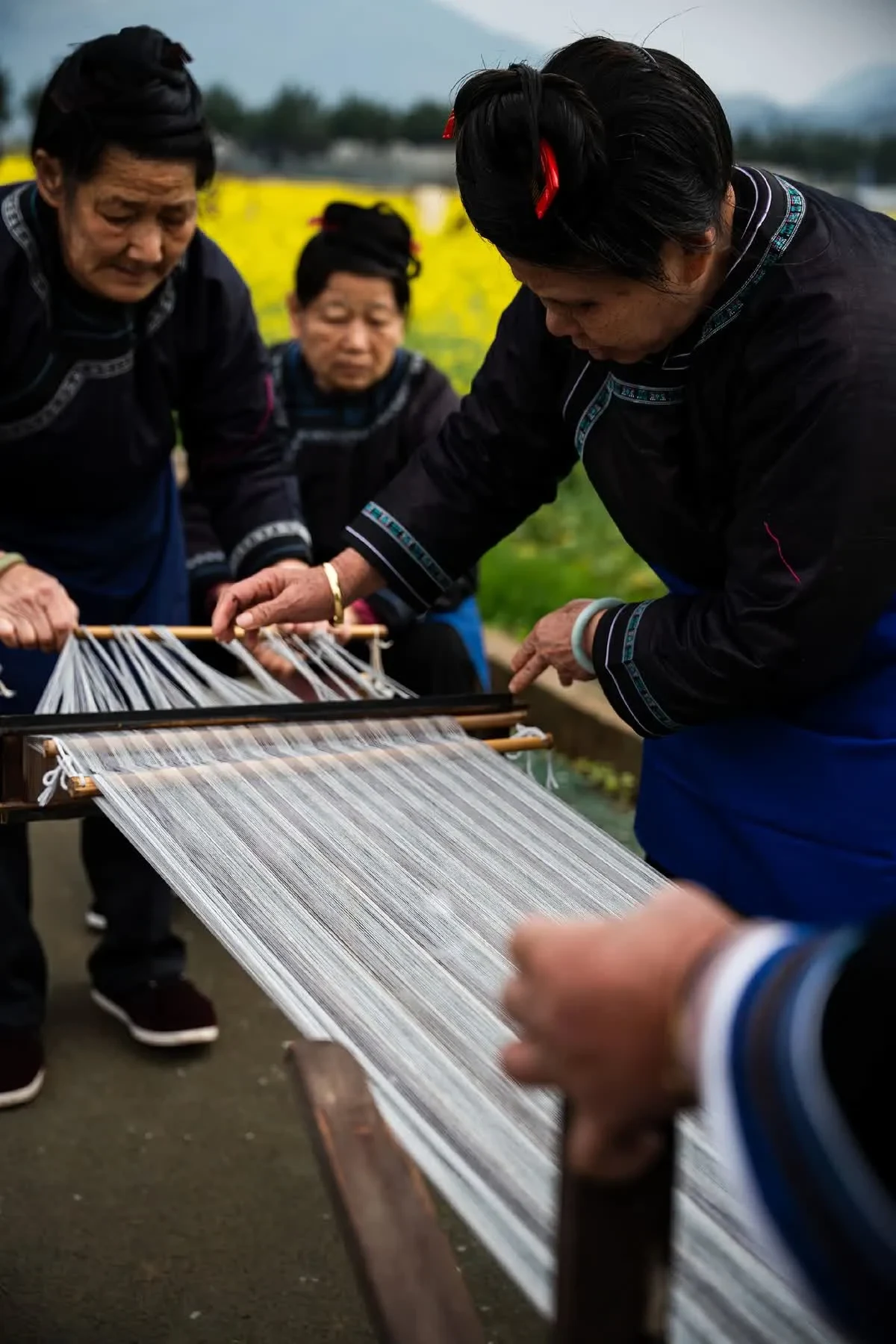 Artisan arranging warp threads for weaving